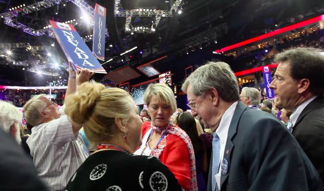 Washoe County GOP chairman Dave Buell wrests the Nevada delegation's state sign off its pole, being held by Nevada delegate Kim Bacchus, after the close of the Republican National Convention Thursday night Aug. 30, 2012 in Tampa, as National Committeewoman Heidi Smith, National Committeeman Bob List and Lieutenant Governor Brian Krolicki look on.